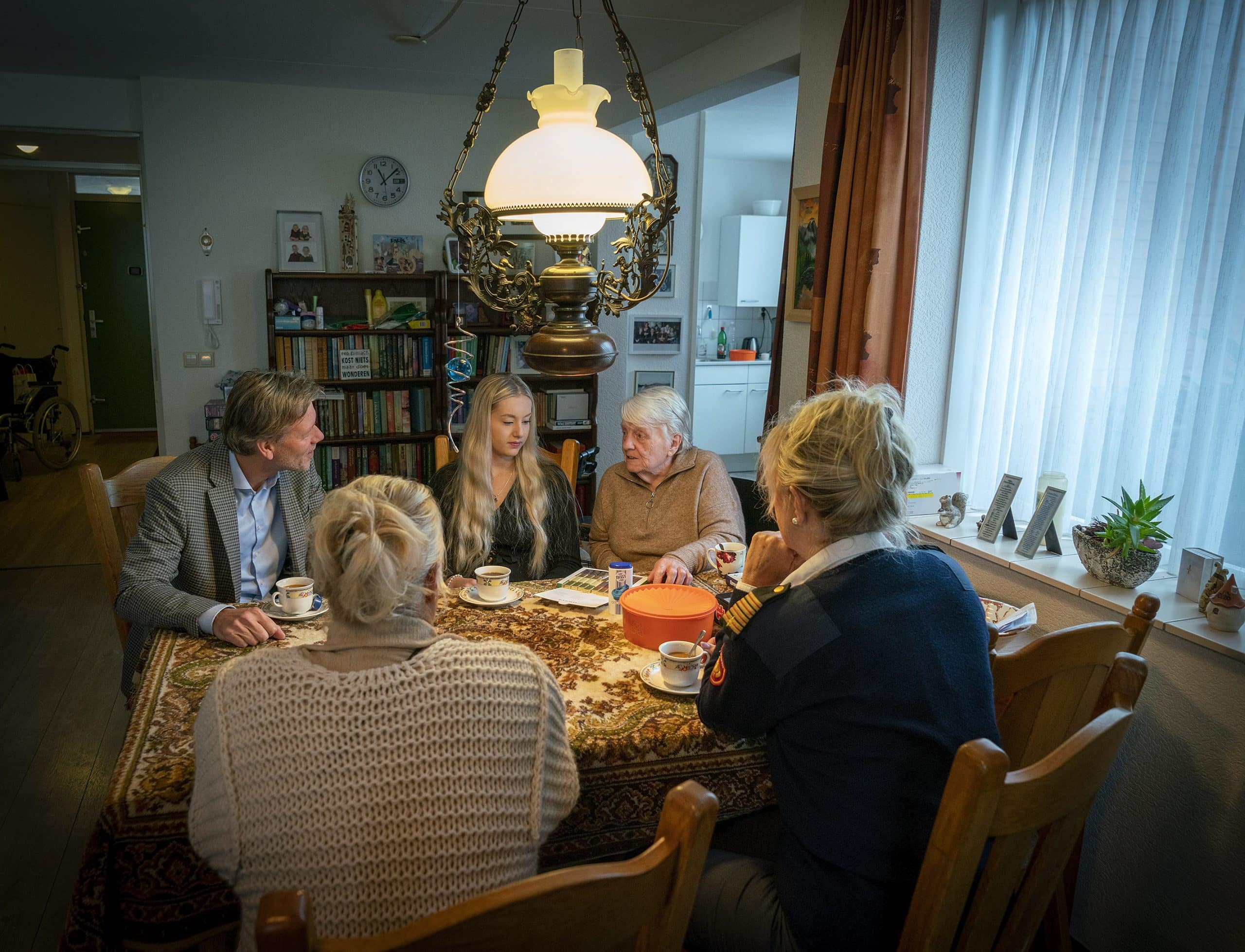 Een meneer en vier vrouwen aan tafel met elkaar in gesprek