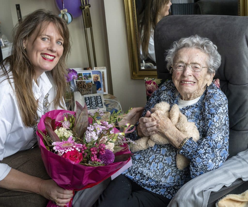 Burgemeester Anja Schouten (links op de foto) met bos bloemen voor 105-jarige mevrouw Wiedeman-Benz