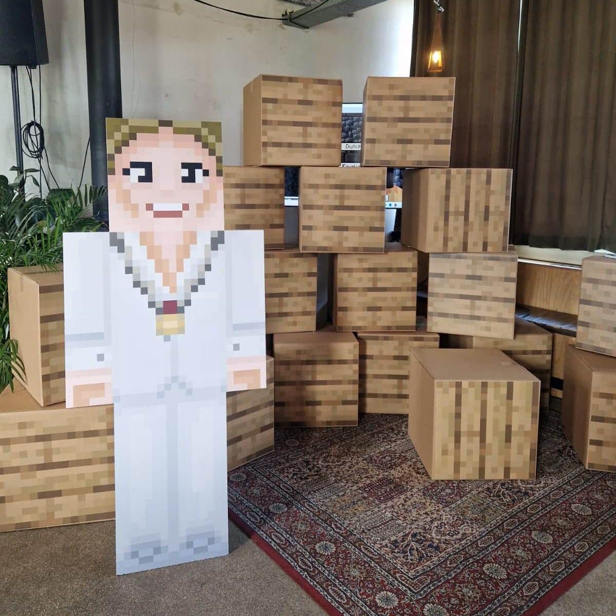 De Minecraft muur die wethouder Schouten samen met de kinderen doorbrak om het project te openen. En Burgemeester Anja Schouten als Minecraft figuur. 