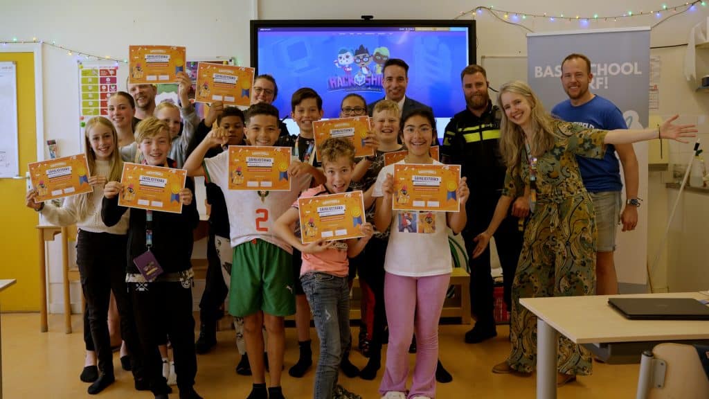 Kinderen  van groep 8 van basisschool DURF Tochtwaard met hun certificaat van HackShield. Wethouder Onderwijs Jasper Nieuwenhuizen en een jeugdagent hebben zojuist de certificaten uitgereikt aan de winnende klas.