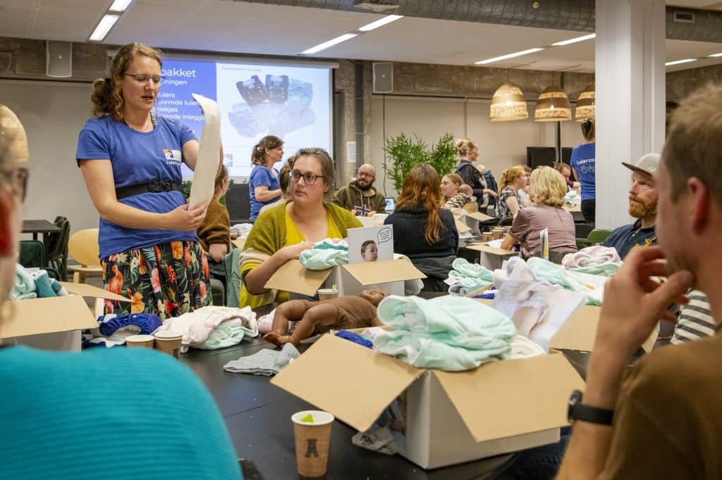 Een luiercoach legt aan ouders uit hoe een wasbare luier werkt. 