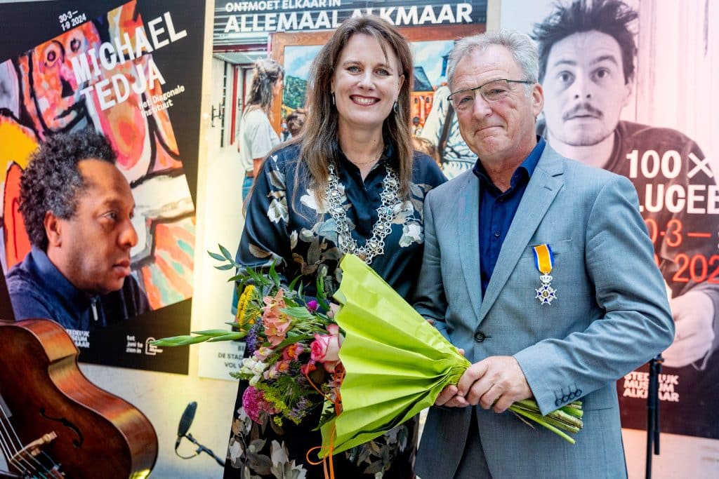 Links op de foto burgemeester Anja Schouten met naast haar Patrick van Mil met bloemen en zijn Koninklijke Onderscheiding die zojuist is opgespeld. Foto JJFoto