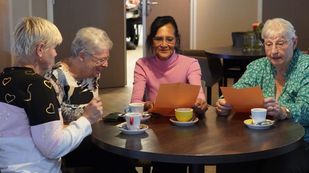 Op de foto 4 mensen die samen eten in een buurthuis in Alkmaar