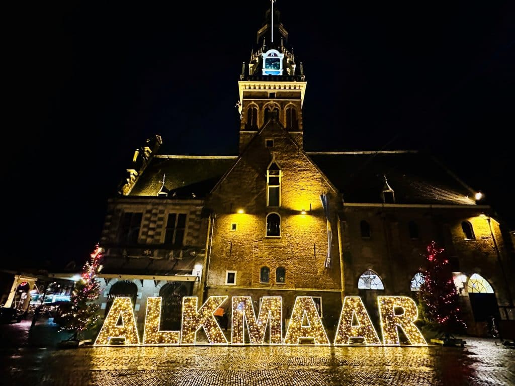 Verlichte letters ''Alkmaar'' met toren op de achtergrond