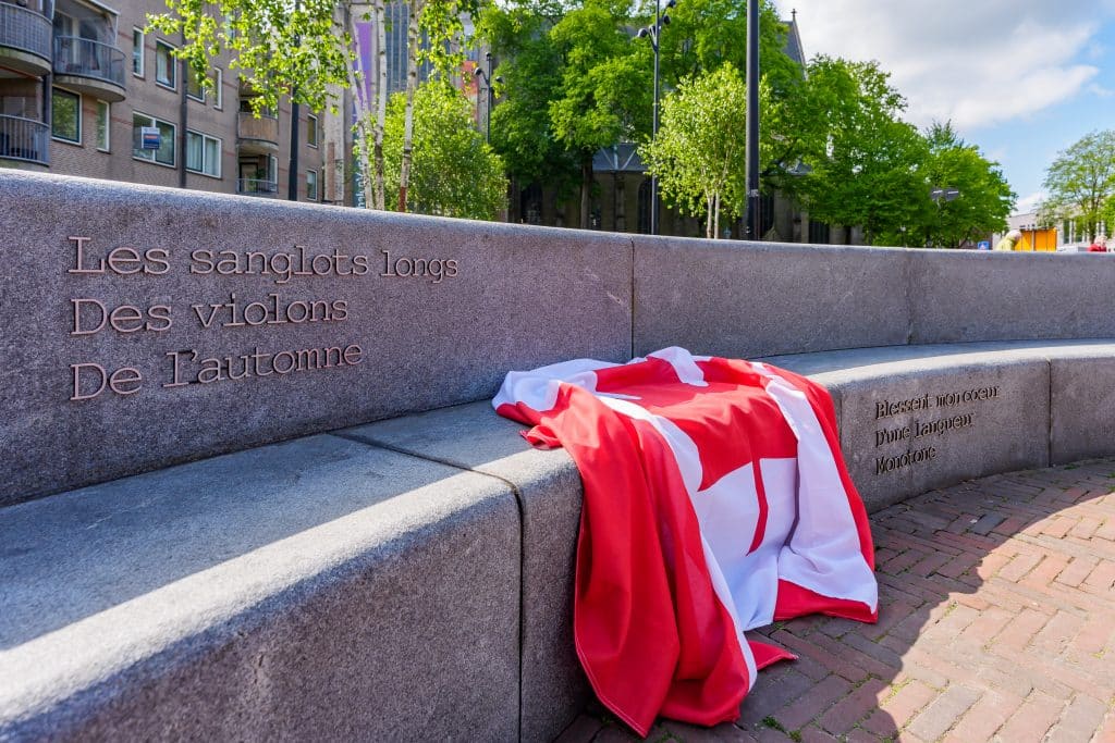 Foto van dichtregels op het Canadaplein met de Canadese vlag erop