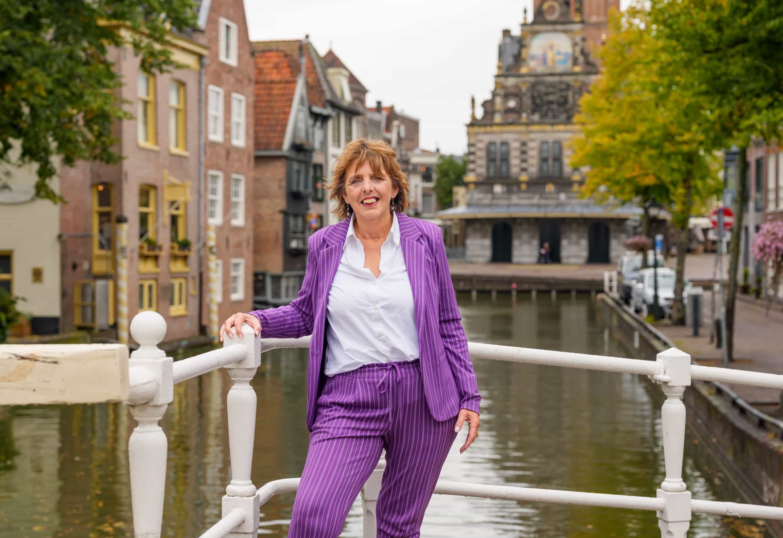 Astrid staat op het bruggetje met de waagtoren op de achtergrond