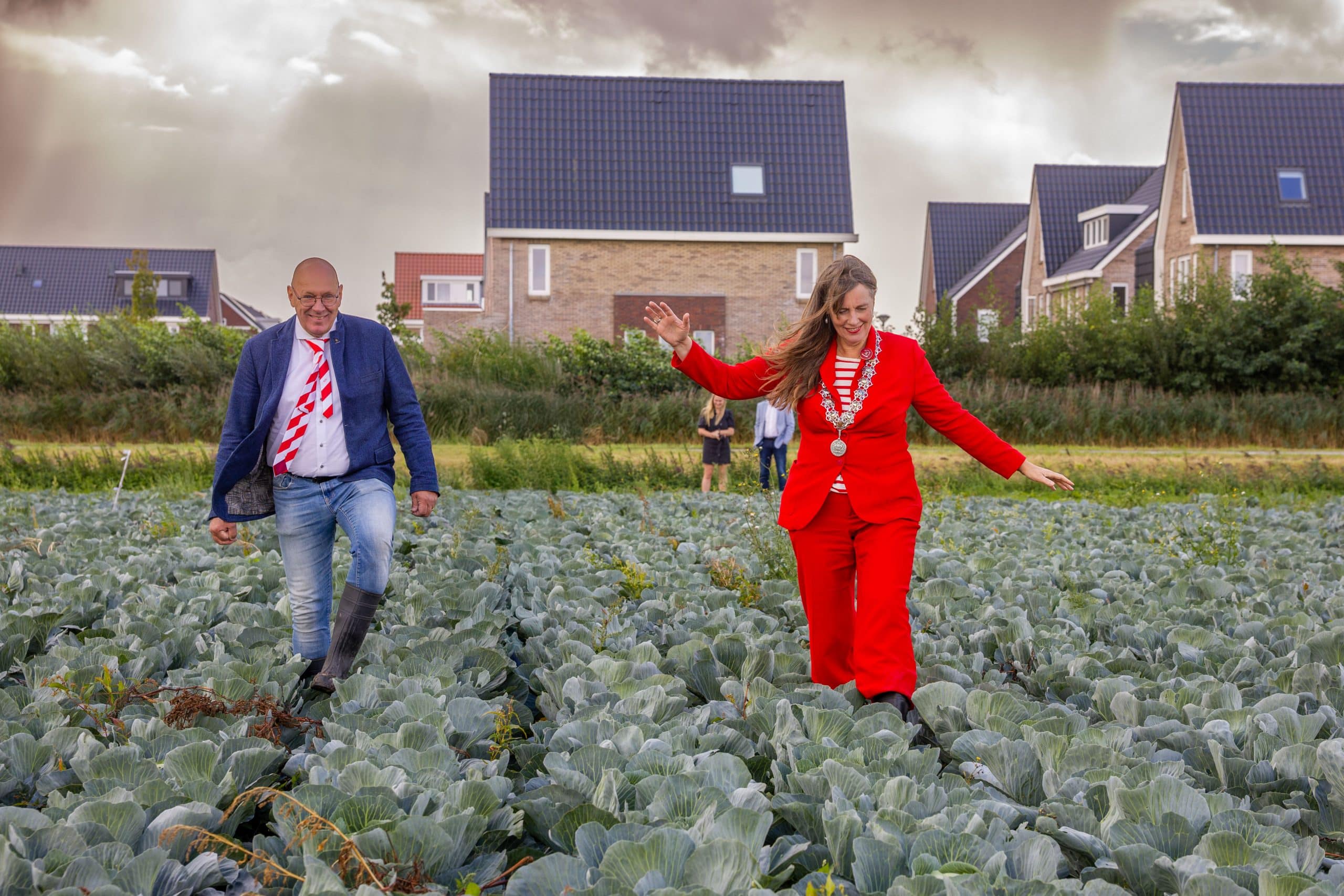 Rob Boerlage van de8 October Vereeniging en burgemeester Schouten van de gemeente Alkmaar lopen samen door een kolenveld.