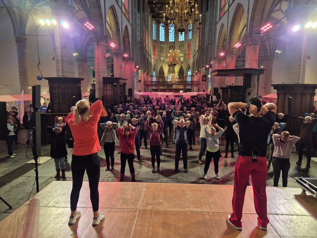 Groep mensen volgt een beweeg workshop in de Grote Kerk