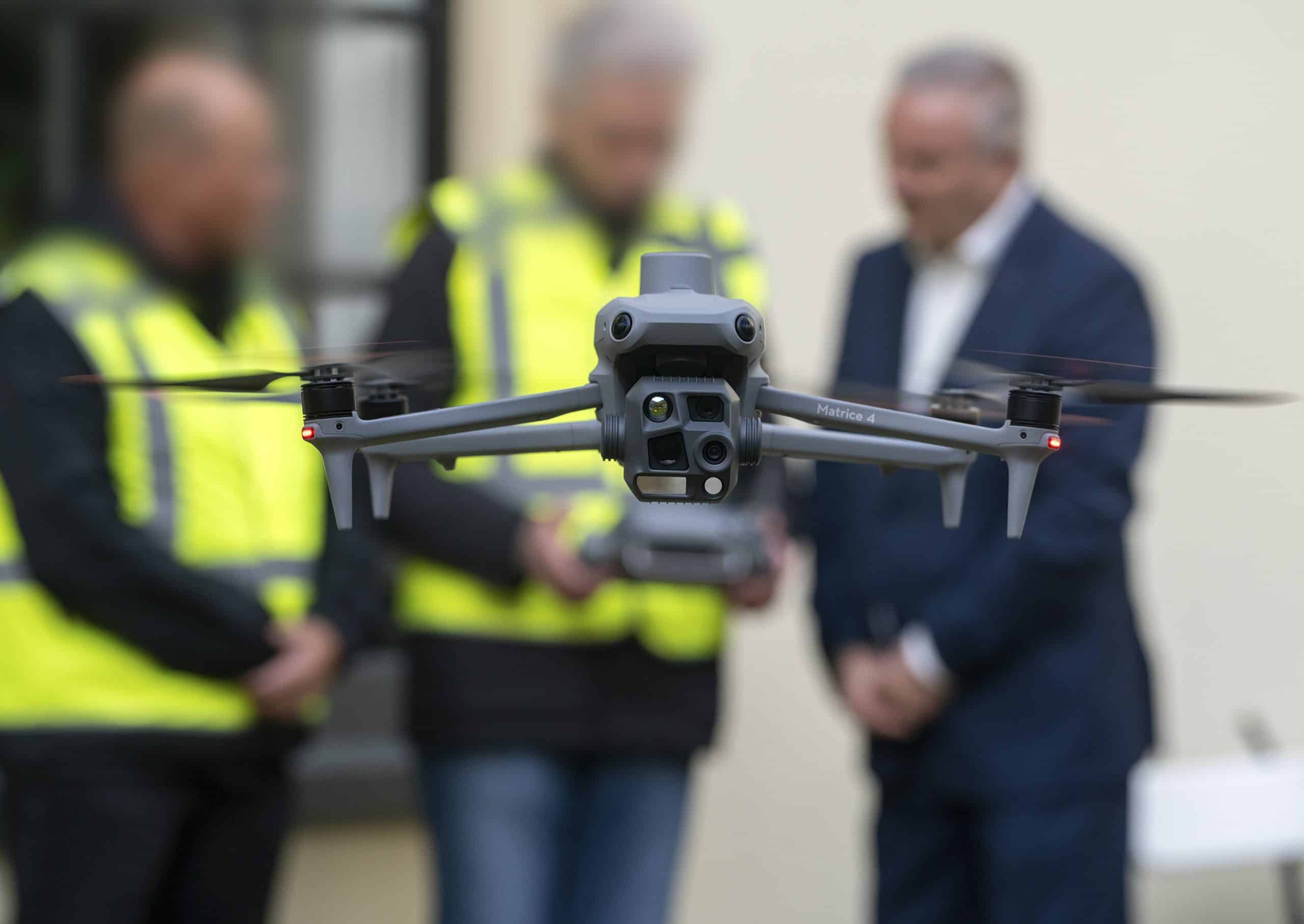 Drone van de gemeente Alkmaar wordt bestuurd door twee ambtenaren in gele hesjes. De wethouder kijkt met hen mee op het scherm.