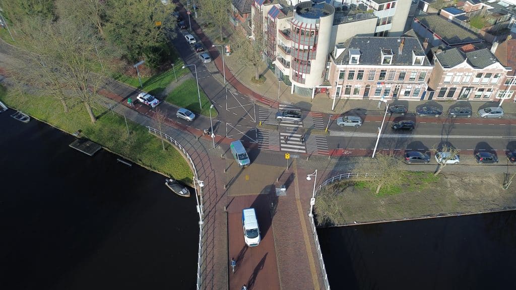 Luchtfoto van de Bergerbrug en de kruising met de Geestersingel in Alkmaar, met auto’s, fietsers en voetgangers.