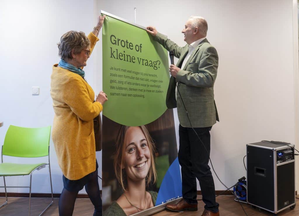 man en vrouw hangen poster op