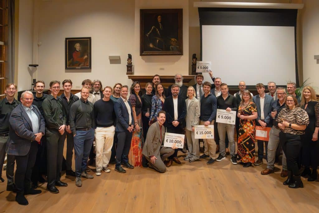 Groepsfoto van ondernemers. De prijswinnaars houden cheques vast met daarop het bedrag wat ze gewonnen hebben.