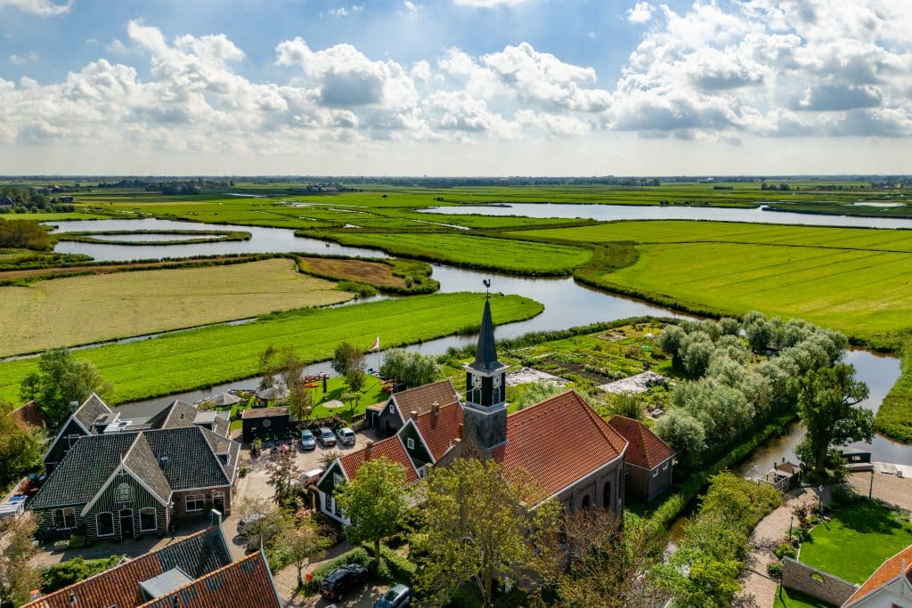 Luchtfoto van het dorp Driehuizen met de kerk duidelijk in beeld 