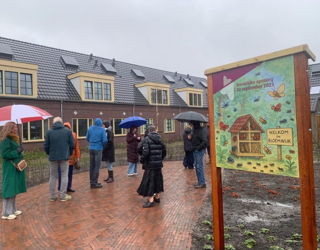 bewoners maken wandeltocht door de regen in Bloemwijk